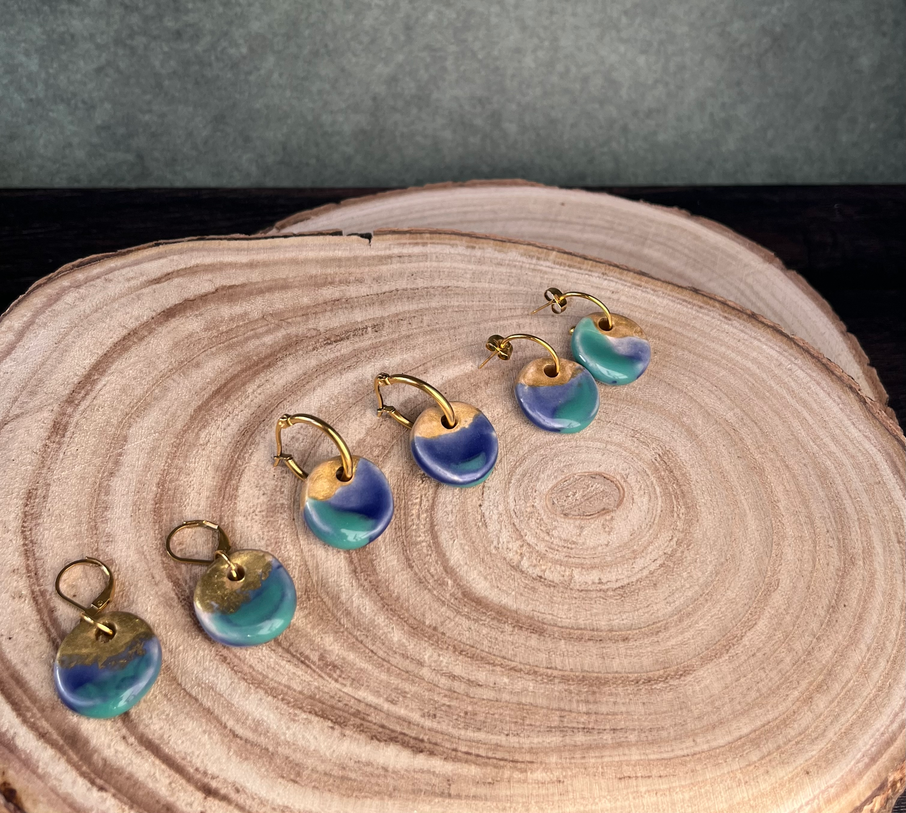 Boucles d'oreilles de la Collection Origines sur une tranche de bois